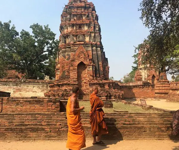 Monks walking past a prang in Ayutthaya