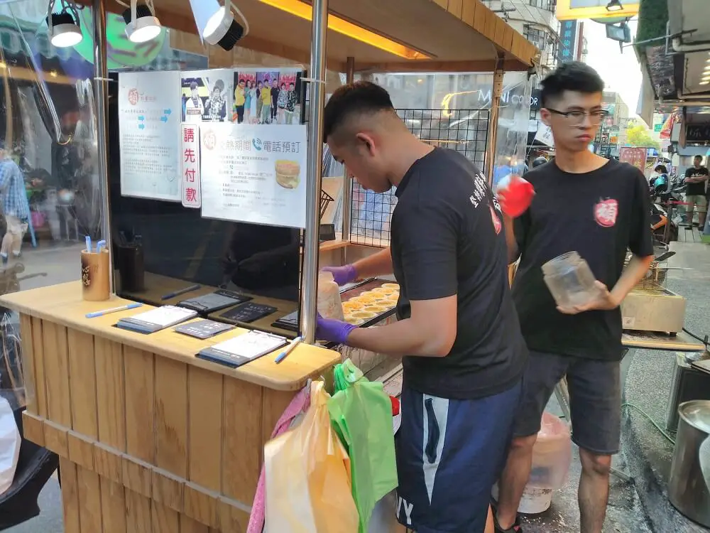 Two food vendors cooking at their stall