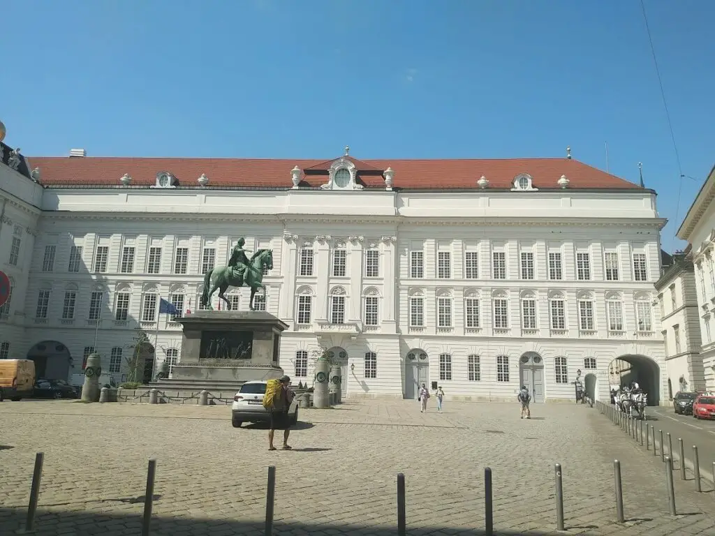 A statue of a man riding a horse outside of the Hofburg in Vienna, Austria